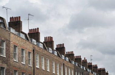 Chimney houses in London against cloudy sky.