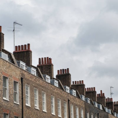 Chimney houses in London against cloudy sky.