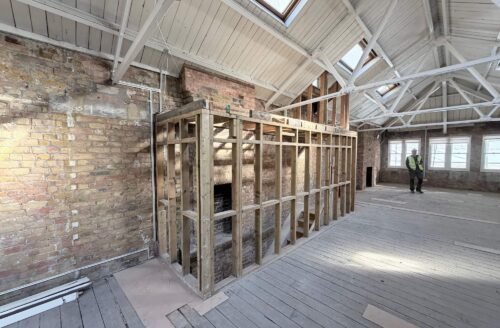 Structural works underway inside a London commercial property with exposed floor joists and contractors on site