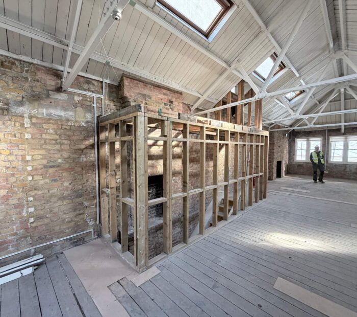 Structural works underway inside a London commercial property with exposed floor joists and contractors on site