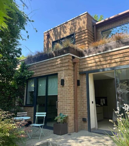 Modern rear extension to a London property with brickwork, large glazed doors and landscaped garden