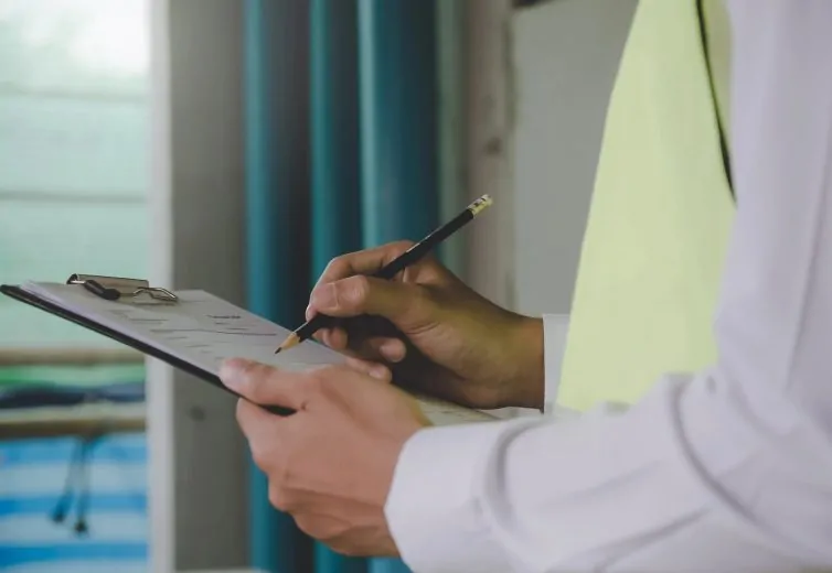 A chartered surveyor reviewing and taking notes on a property inspection.