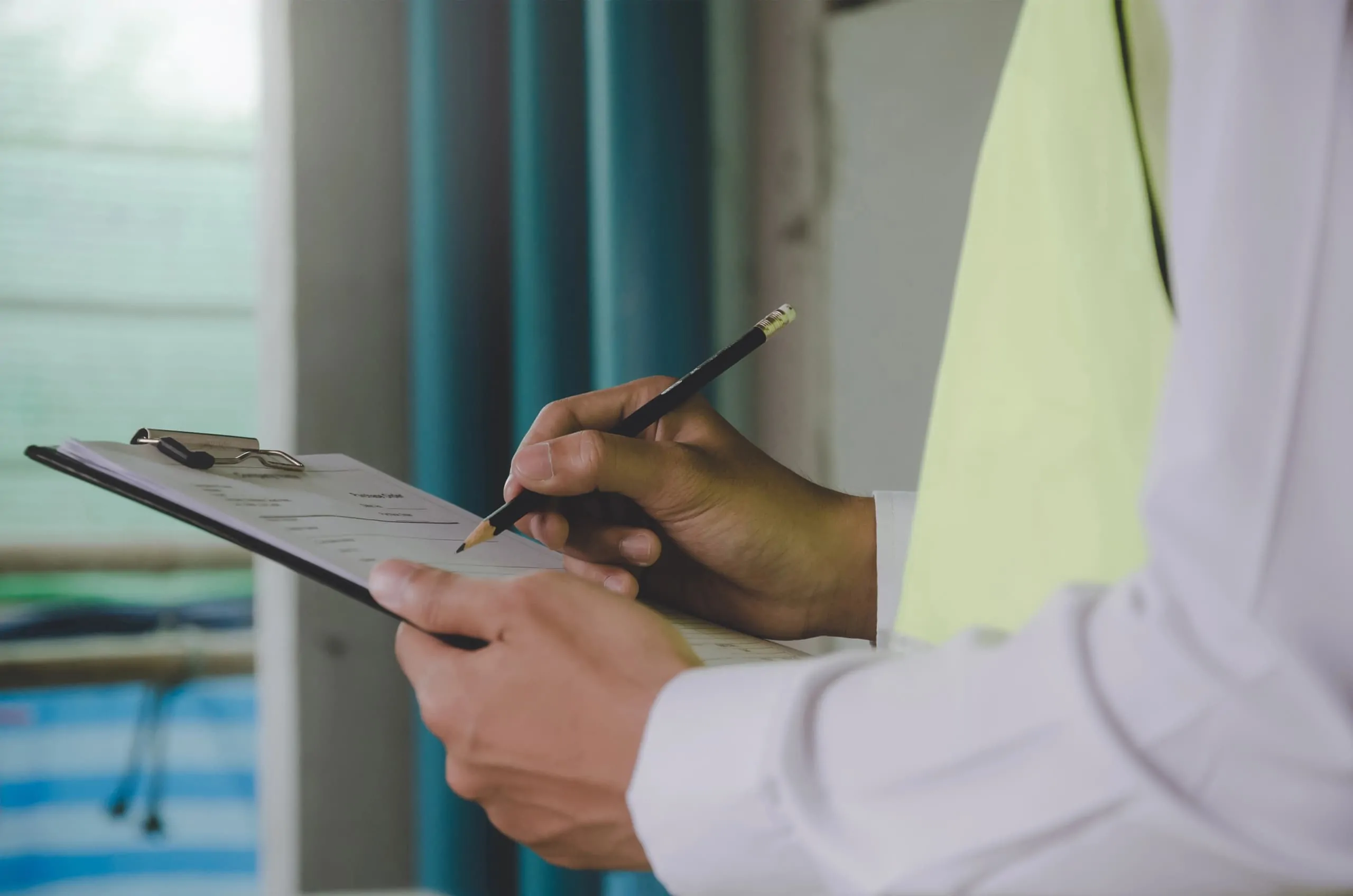 A chartered surveyor reviewing and taking notes on a property inspection.