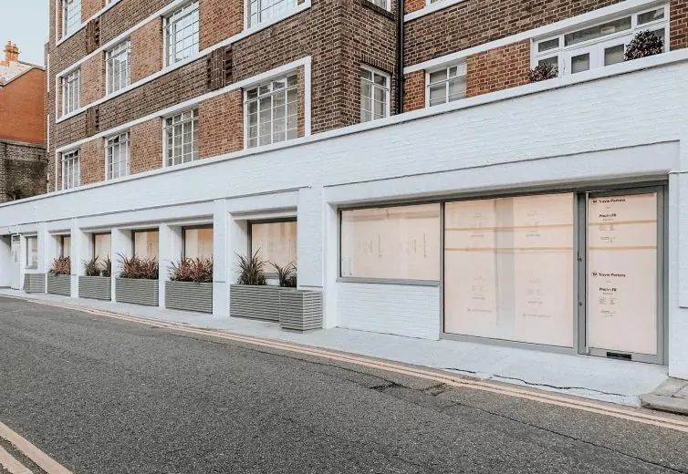 Exterior of a brick building with planters, showcasing modern architectural design and large windows.