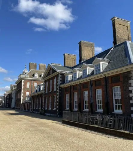 Historic brick buildings with traditional architecture, showcasing grand design and large windows under a clear blue sky.