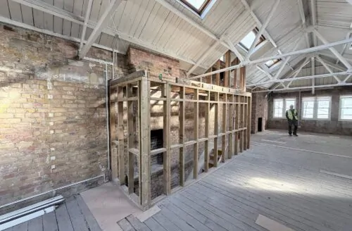 Structural works underway inside a London commercial property with exposed floor joists and contractors on site